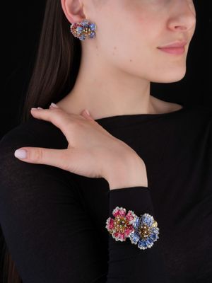 La femme porte un t-shirt noir et une paire de boucles d'oreilles.