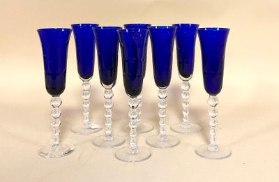 six verres à vin bleus sont alignés sur une surface blanche