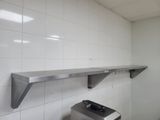 a picture of a kitchen with a stove and a wall mounted shelf