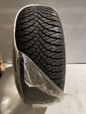 a close up of a tire on a white surface with a piece of plastic covering it