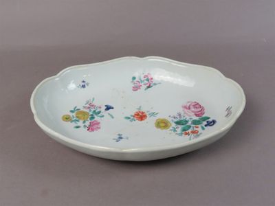 un bol blanc orné de fleurs, posé sur une table