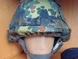un casque posé sur une étagère, avec un chapeau posé dessus