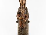 a wooden statue of a woman holding a child