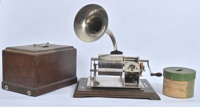 un vieux gramophone à côté d'une boîte et d'un rouleau de papier toilette