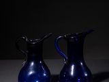 two blue vases sitting on a table in the dark