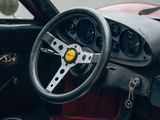 a steering wheel and dashboard of a red sports car