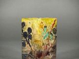 a yellow and black vase sitting on top of a table
