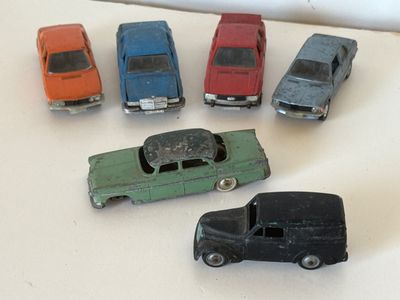 Plusieurs petites voitures sont alignées sur une surface blanche