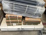 un tas de tiges métalliques et d'autres objets posés sur une palette dans un entrepôt