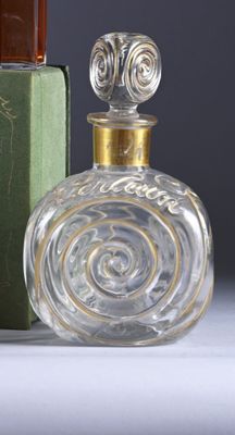 a bottle of perfume next to a box of books