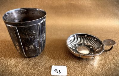 a silver cup and a silver spoon on a table