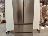 a stainless steel refrigerator sitting on a pallet in a warehouse