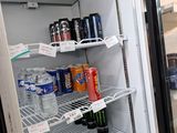 a refrigerator that has a lot of drinks and sodas in it