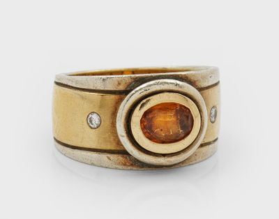 a close up of a ring with an orange stone in it