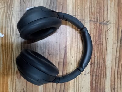 un casque audio noir posé sur une table en bois