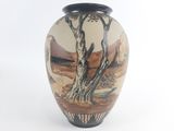 a vase with a painting on it sitting on a table