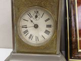 a clock sitting next to a picture frame on a table