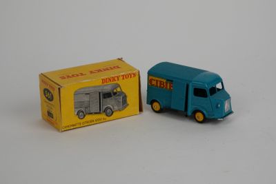 un camion miniature et une boîte posés sur une surface blanche