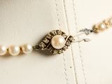 a white necklace with pearls and a silver clasp on it