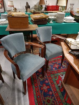 many chairs and a table in a room with a blue table cloth