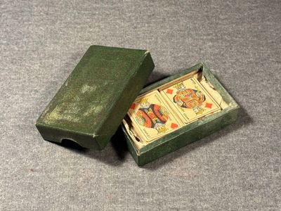 two playing cards in a green box on a table