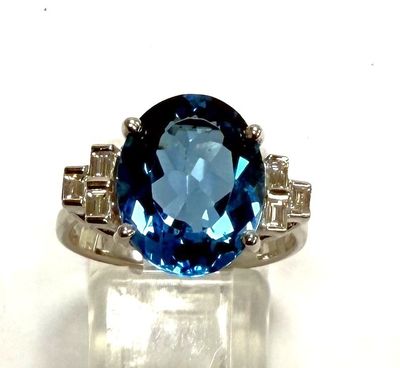 an image of a ring with a blue topaz stone surrounded by diamonds