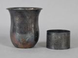 a silver vase and a silver cup sitting next to each other