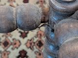 a close up of a wooden chair with a rug in the background