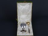 a silver spoon and spoon rest in a green box on a black background