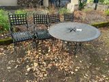 une photo représentant une table et quatre chaises dans un jardin