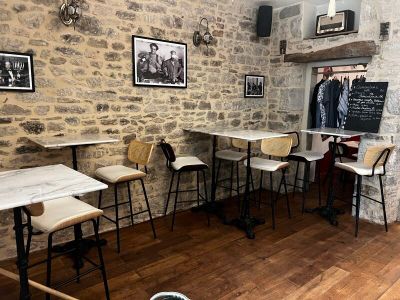 des tables et des chaises dans une pièce aux murs en briques et au sol en parquet