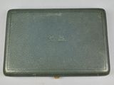 an old green leather case with a small hole in the middle