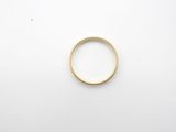 a gold wedding ring on a white surface