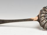 silver spoon on a white surface with a label on it
