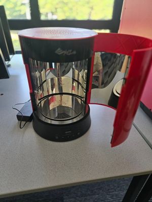 une cafetière rouge et noire posée sur une table