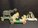 three wooden animals that are sitting on top of a toy car