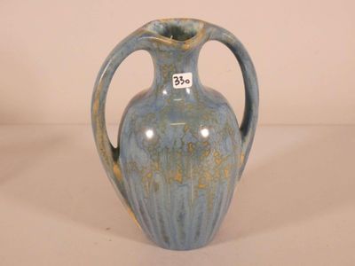 un vase bleu muni d'une étiquette, posé sur une table