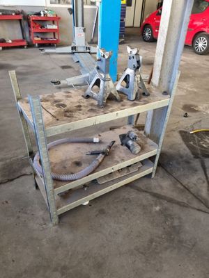 certains outils sont posés sur une étagère en bois dans un garage