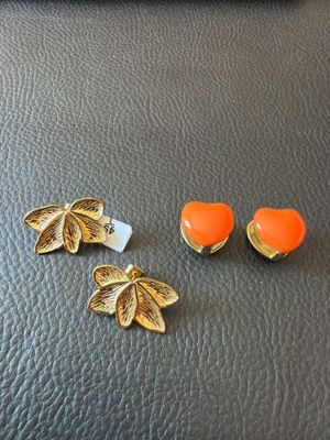 un gros plan sur une paire de boucles d'oreilles posées sur une surface en cuir