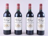 trois bouteilles de vin rouge sont alignées sur une surface blanche