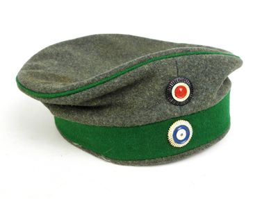un chapeau vert orné d'un cache-œil rouge et bleu