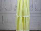 a yellow dress on a mannequin stand on a wooden floor