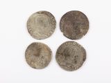 trois pièces d'argent, dont l'une représente la tête d'une femme et une autre celle d'une