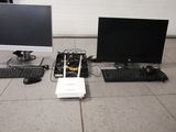 deux écrans d'ordinateur, un clavier et une souris posés par terre