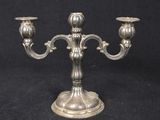 an antique silver plated candelab with two candles on a stand
