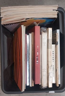 de nombreux livres dans un bac en plastique posé par terre