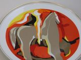a plate with a painting of two horses on it