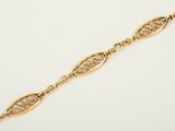 a gold bracelet with an intricate design on it