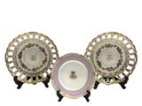 three plates with gold rims and a purple and white plate