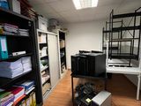 a room with a desk, shelves, and a computer